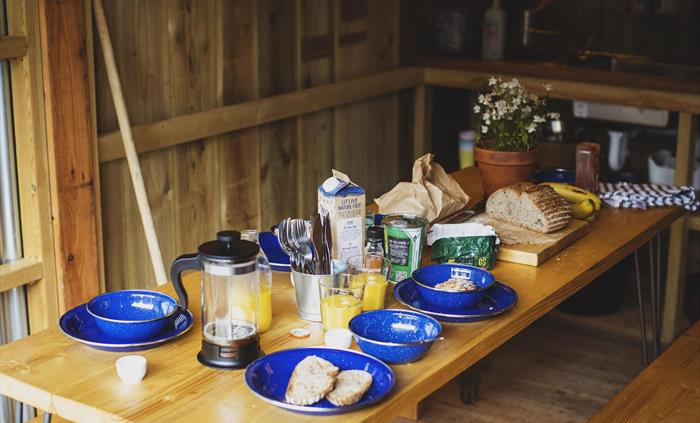 A table set for breakfast in a an outdoor cabin kitchen.